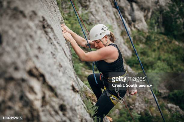 eine starke junge kletterin klettert auf den felsen - freeclimber stock-fotos und bilder