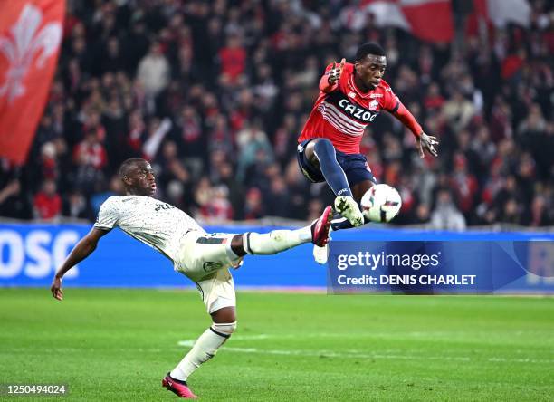 Lorient' French forward Yoann Cathline fights for the ball with Lille's US forward Timothy Weah during the French L1 football match between Lille...