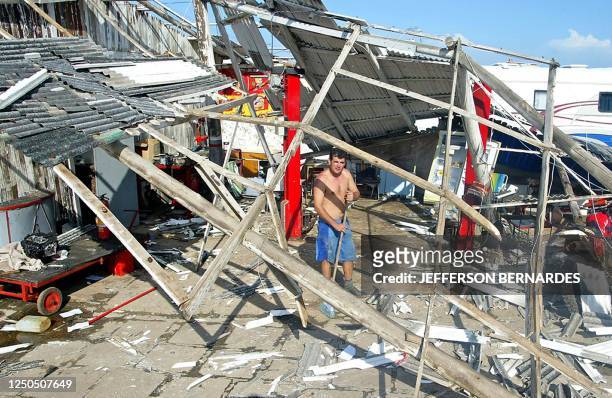 Man sweeps the remains of his house destroyed by hurricane "Catarina" 28 March 2004 in Torres, 200kms from Porto Alegre, in Rio Grande do Sul,...