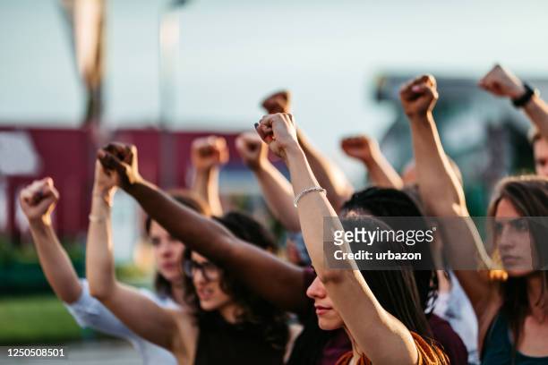 manifestanti che alzano i pugni - dimostrazione di protesta foto e immagini stock