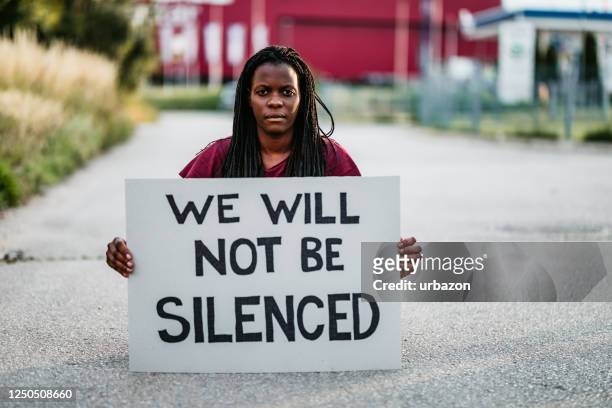 "we zullen niet het zwijgen worden opgelegd" bordje - activists protests outside of trump tower in chicago stockfoto's en -beelden