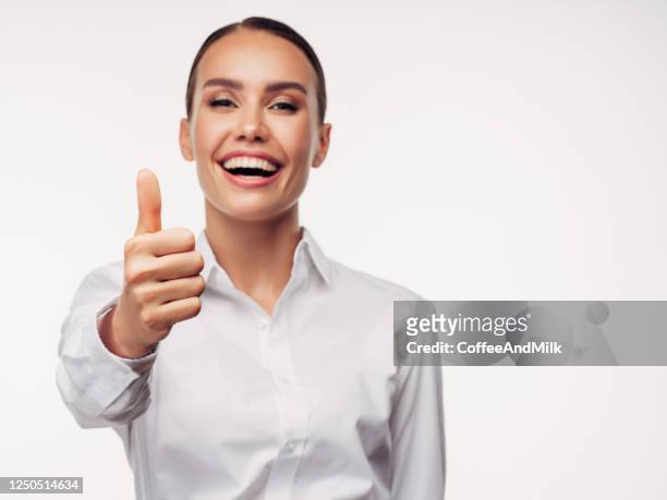 donna felice che mostra un segno ok davanti allo sfondo bianco - ok foto e immagini stock
