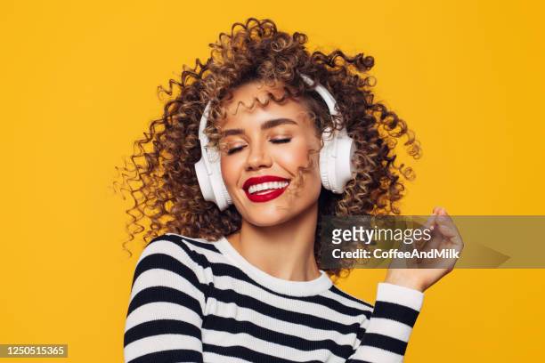 hermosa mujer con auriculares blancos escucha música - women dancing on music cutout fotografías e imágenes de stock