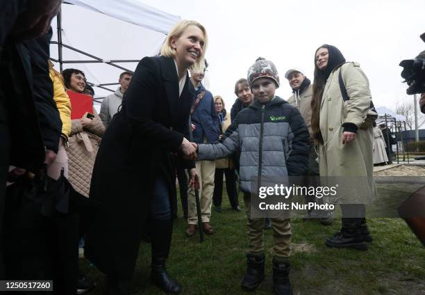 Ambassador to Ukraine Bridget Brink shake hands with a local boy on the first anniversary of the retreat of Russian forces from Kyiv region, in...