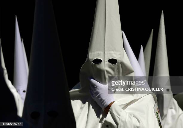 Penitents of La Paz brotherhood take part in the Palm Sunday procession in Seville on April 2, 2023. - Spain's colourful Holy Week celebrations begin...