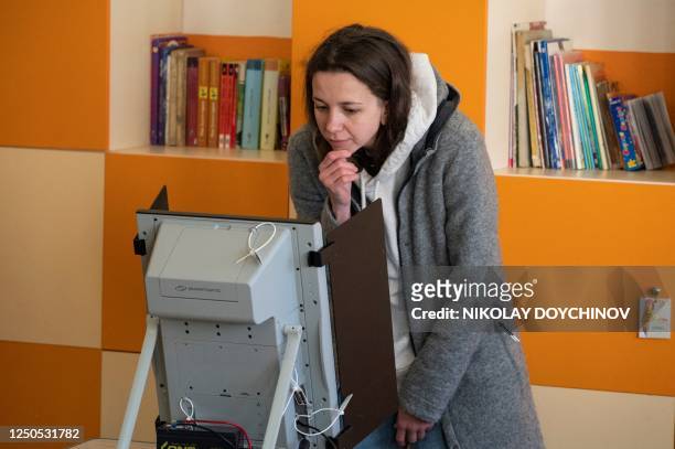 Woman votes in Bulgarian parliamentary elections at a polling station in Sofia on April 2, 2023. - Bulgarians voted in their fifth general election...