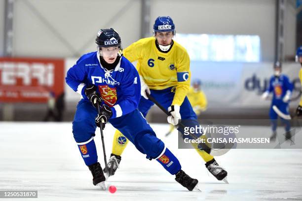 Finland's Riku Hämäläinen and Sweden's Martin Karlsson vie during the bandy final between Sweden and Finland in the Men's Bandy World Cup in Eriksson...