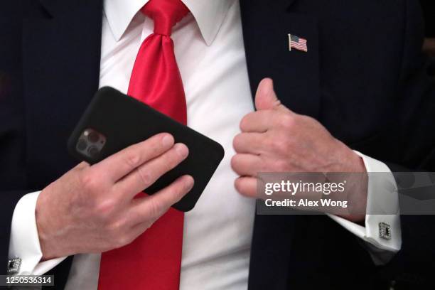 President Donald Trump put his phone in his pocket during a roundtable at the State Dining Room of the White House June 18, 2020 in Washington, DC....