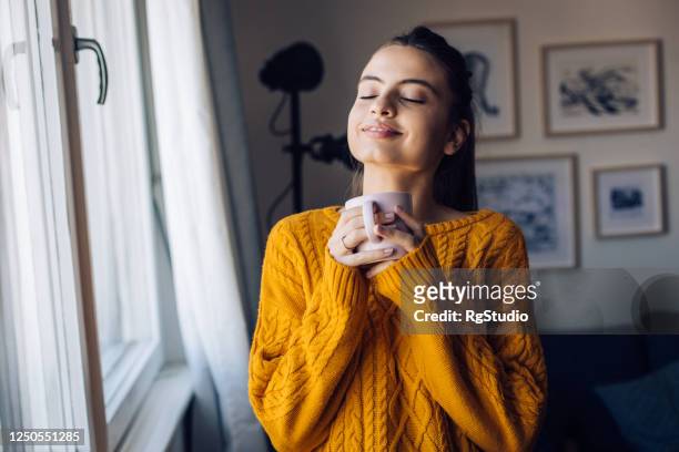 portrait of a happy girl enjoying morning coffee at home - woman with eyes closed stock pictures, royalty-free photos & images