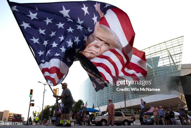 Trump supporter Randall Thom waves a giant Trump flag to passing cars outside the BOK Center June 18, 2020 in Tulsa, Oklahoma. Trump is scheduled to...