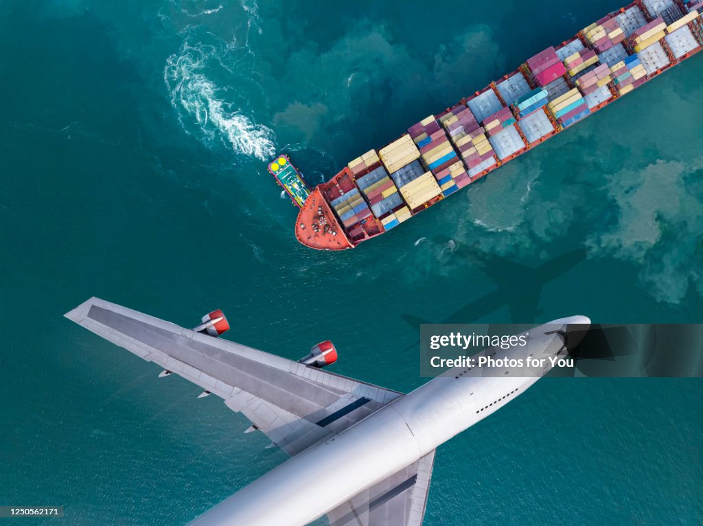 Aerial view/The plane flew past a cargo ship that was leaving the harbor, with a truckboat spinning a large ship. Business and transportation are being driven after the effects of the coronal virus, or Covid-19