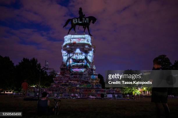 George Floyd's image is projected on the Robert E. Lee Monument as people gather around on June 18, 2020 in Richmond, Virginia. Richmond Circuit...