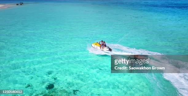 tourist riding jet-ski on water surface in maldives - jet ski stock pictures, royalty-free photos & images