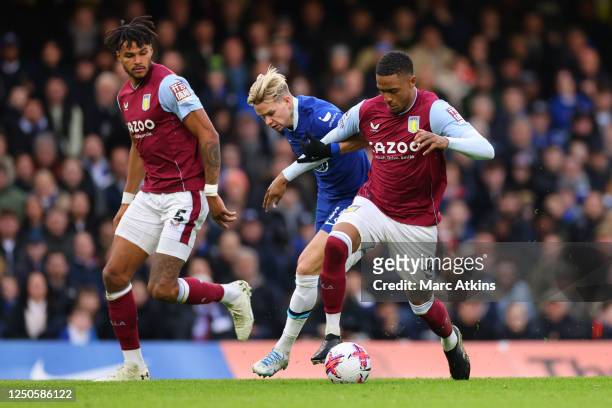 Mykhailo Mudryk of Chelsea tangles with Ezri Konsa and Tyrone Mings of Aston Villa during the Premier League match between Chelsea FC and Aston Villa...