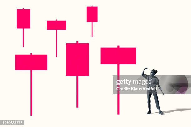 woman shielding eyes by large pink placards - political uncertainty stock pictures, royalty-free photos & images