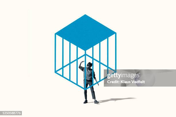 young woman shielding eyes under blue cage - vastzitten stockfoto's en -beelden