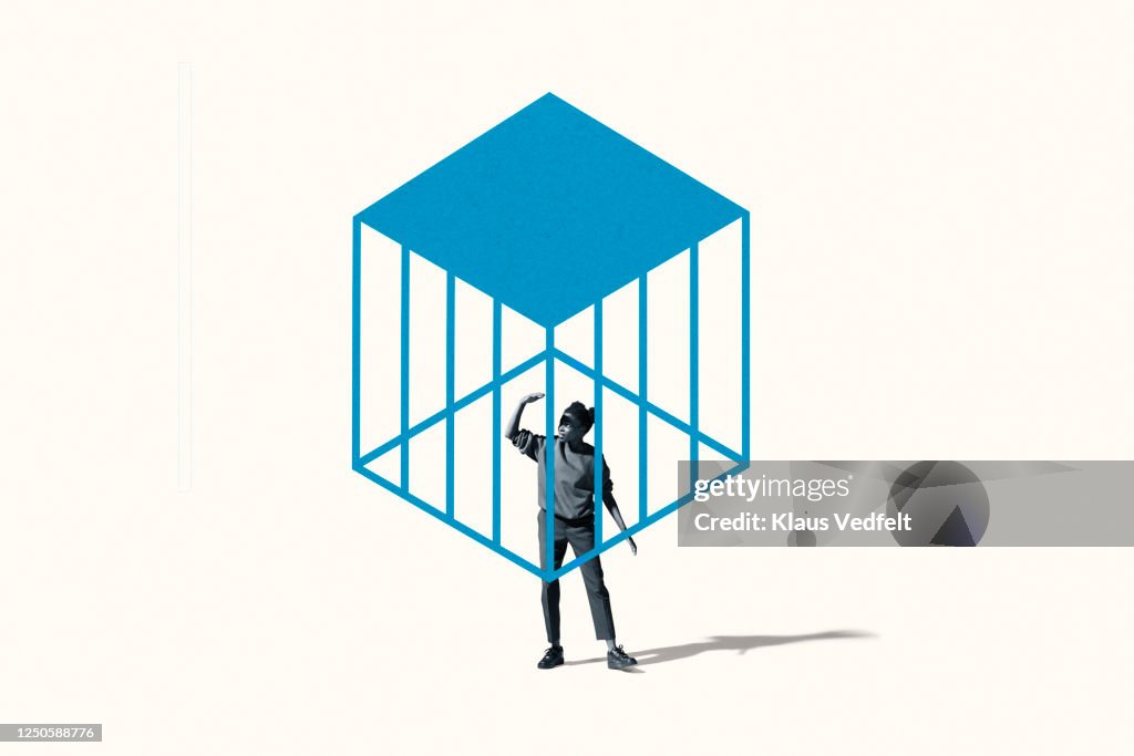 Young woman shielding eyes under blue cage