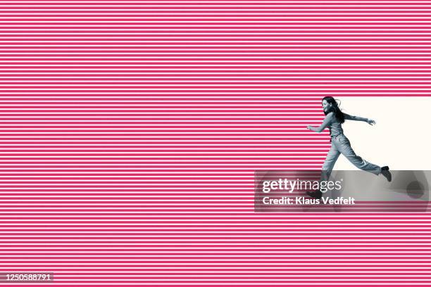 smiling woman running on pink striped pattern - impacto stock-fotos und bilder