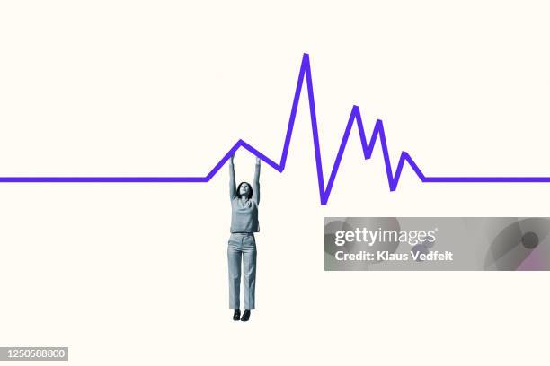 woman hanging from purple line graph for survival - line graph down stock pictures, royalty-free photos & images