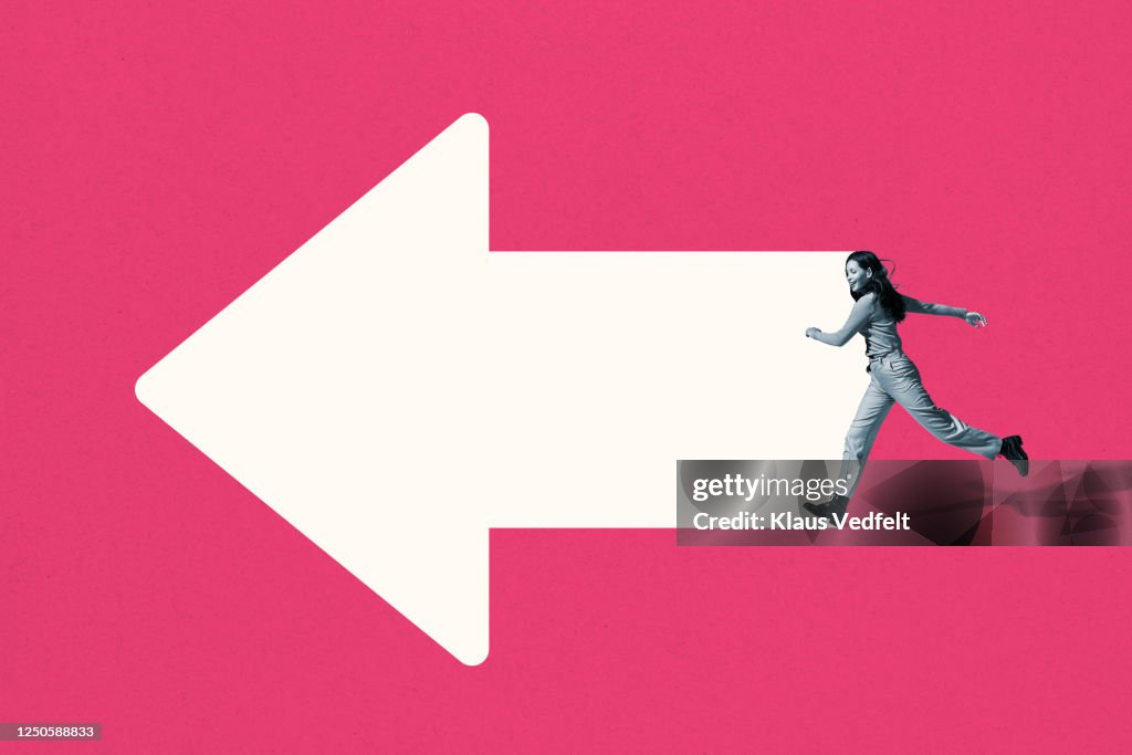 Happy young woman running on white arrow