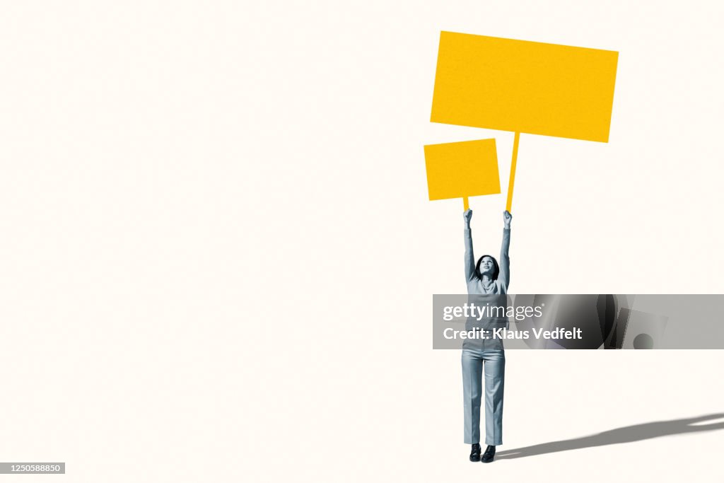 Female protestor holding blank yellow placards