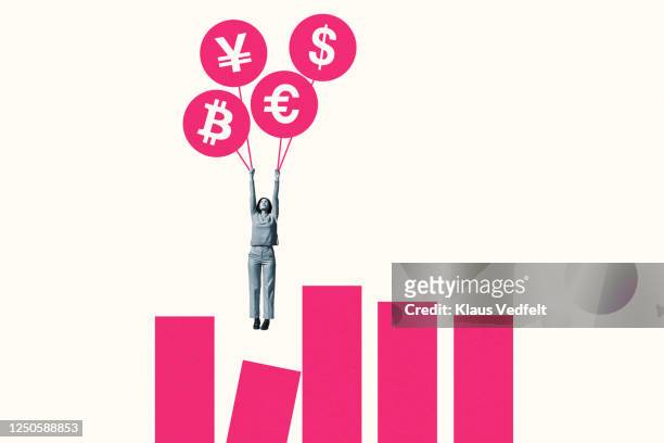 woman hanging from currency balloons over graph - circle graph foto e immagini stock