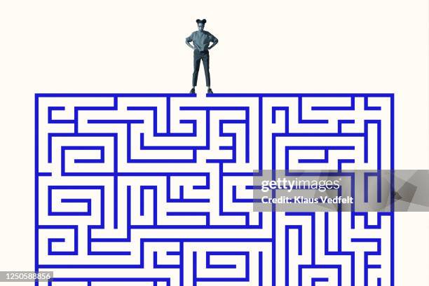 woman standing with hand on hip over blue maze - maze stock pictures, royalty-free photos & images