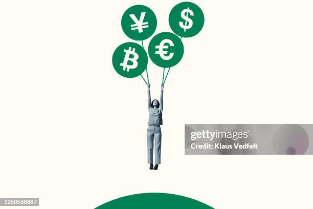 woman hanging from green currency symbol balloons - account money lifestyle stock-fotos und bilder