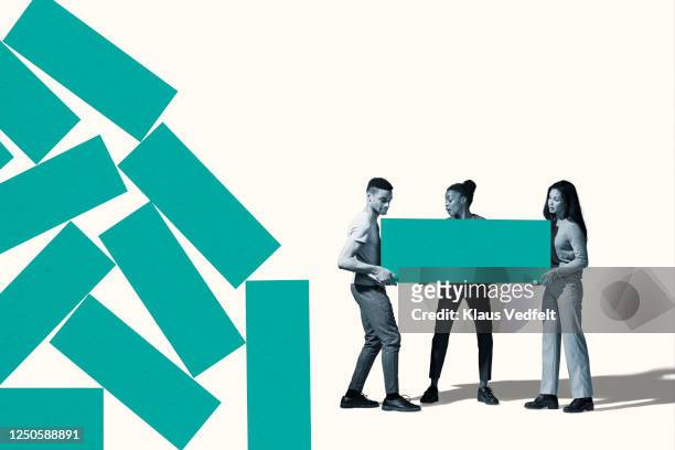 young friends carrying large green block by pile - arranging stock pictures, royalty-free photos & images