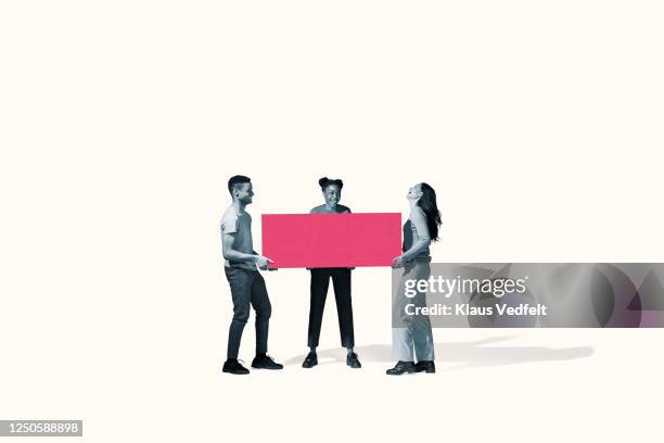 cheerful young friends carrying large pink block - dedication concept stock pictures, royalty-free photos & images