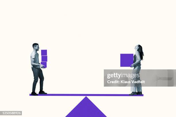 man and woman carrying purple blocks on seesaw - wippe stock-fotos und bilder