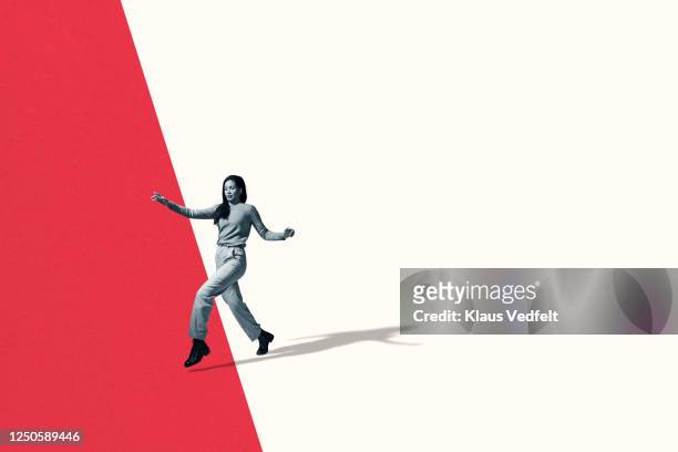 full length of young woman walking in stealth mode - in movimento foto e immagini stock