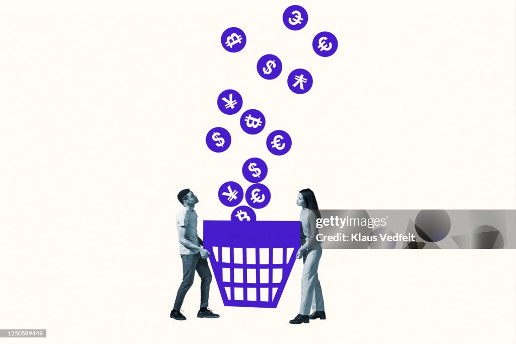Friends catching currency symbols in large basket