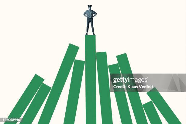 woman standing on top of tall green bar graph - resilienza foto e immagini stock