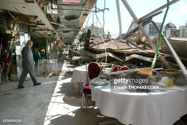 Man walks through the destroyed Park Hotel restaurant in Netanya 28 March 2002 following a suicide bombing late yesterday that killed 20 people plus...