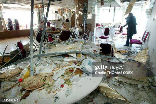 The remains of a Jewish passover meal sit on a table 28 March 2002 following a suicide bombing late 27 March that killed 20 people plus the...
