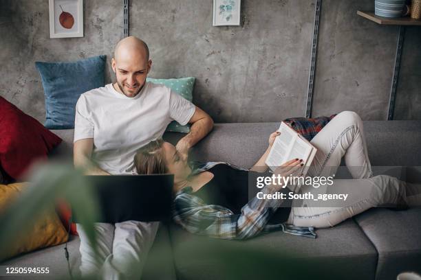 couple relaxing on sofa at home - completely bald woman stock pictures, royalty-free photos & images
