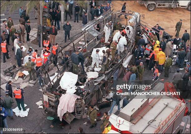 Israeli rescue teams search for bodies of victims inside the wreckage of a bus which was destroyed 03 March 1996 by a suicide bomber in central...