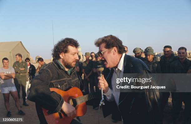 Eddy Mitchell chante avec un soldat à son arrivée dans le camp militaire français de Miramar.