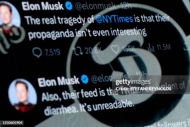 In this photo illustration created on April 2 the profile image of The New York Times Twitter account is reflected in tweets by Twitter CEO Elon...