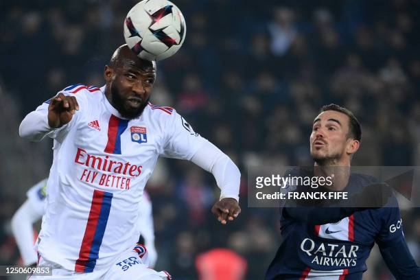 Lyon's French forward Moussa Dembele heads the ball in front of Paris Saint-Germain's Spanish midfielder Fabian Ruiz during the French L1 football...