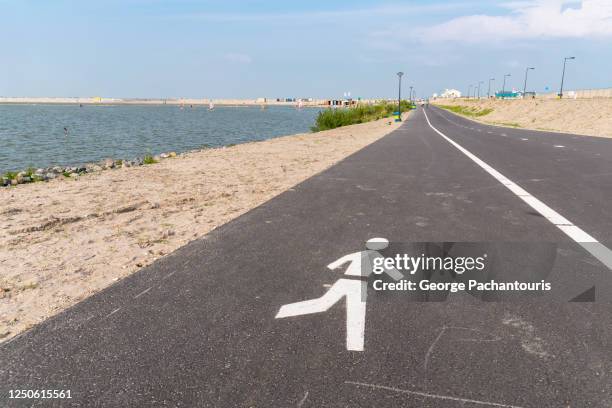 walkway and bicycle lane next to the beach - strand amsterdam stock pictures, royalty-free photos & images