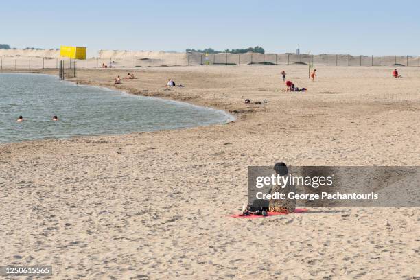 woman with headscarf sitting on a sand beach - strand amsterdam stock pictures, royalty-free photos & images