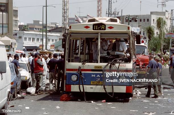 Israeli police officers and rescuers gather on July 1995 around the wreck of bus number 20 in the Ramat Gan suburb of Tel Aviv. A suicide bomber blew...