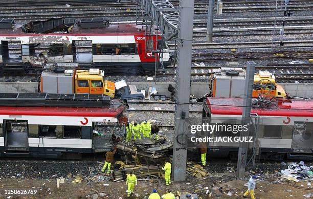 Forensic experts inspect the trains before moving them 12 March 2004 at the Atocha train station. At least 198 people were killed and more than 1400...