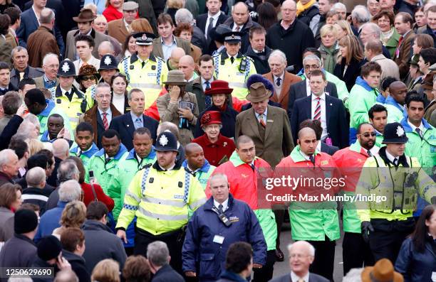 Queen Elizabeth II, surrounded by security guards and police officers, walks to the parade ring as she attends day 4 'Gold Cup Day' of the Cheltenham...