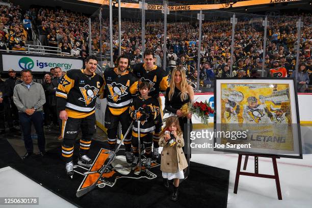 Kris Letang stands with his family, team owner Tom Werner, Sidney Crosby and Evgeni Malkin of the Pittsburgh Penguins before the game celebrating his...