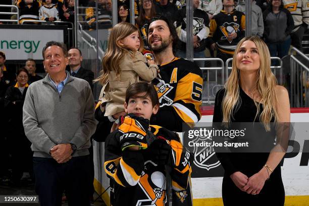 Kris Letang of the Pittsburgh Penguins stands with his family and team owner Tom Werner before the game celebrating his 1,000th career game at PPG...