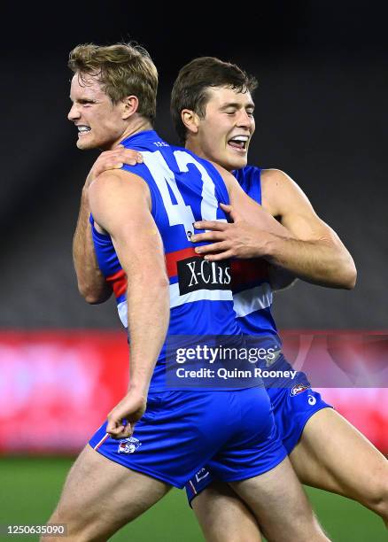 Alex Keath of the Bulldogs is congratulated by Josh Dunkley after kicking a goal during the round 3 AFL match between the Western Bulldogs and the...