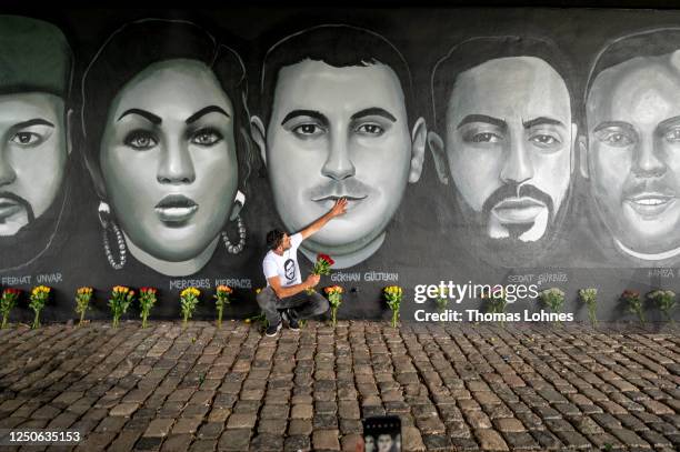Cetin Gueltekin , the brother of Goekhan Gueltekin kneels with some flowers and touches the face of Goekhan in front of a 27 meter long street art...